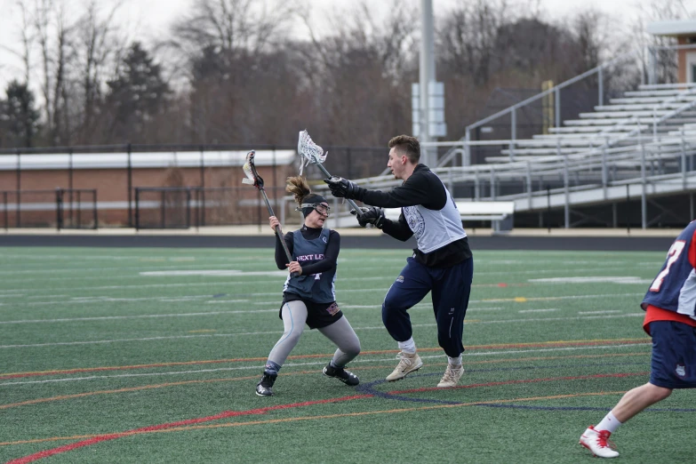 the people are playing lacrosse on the field