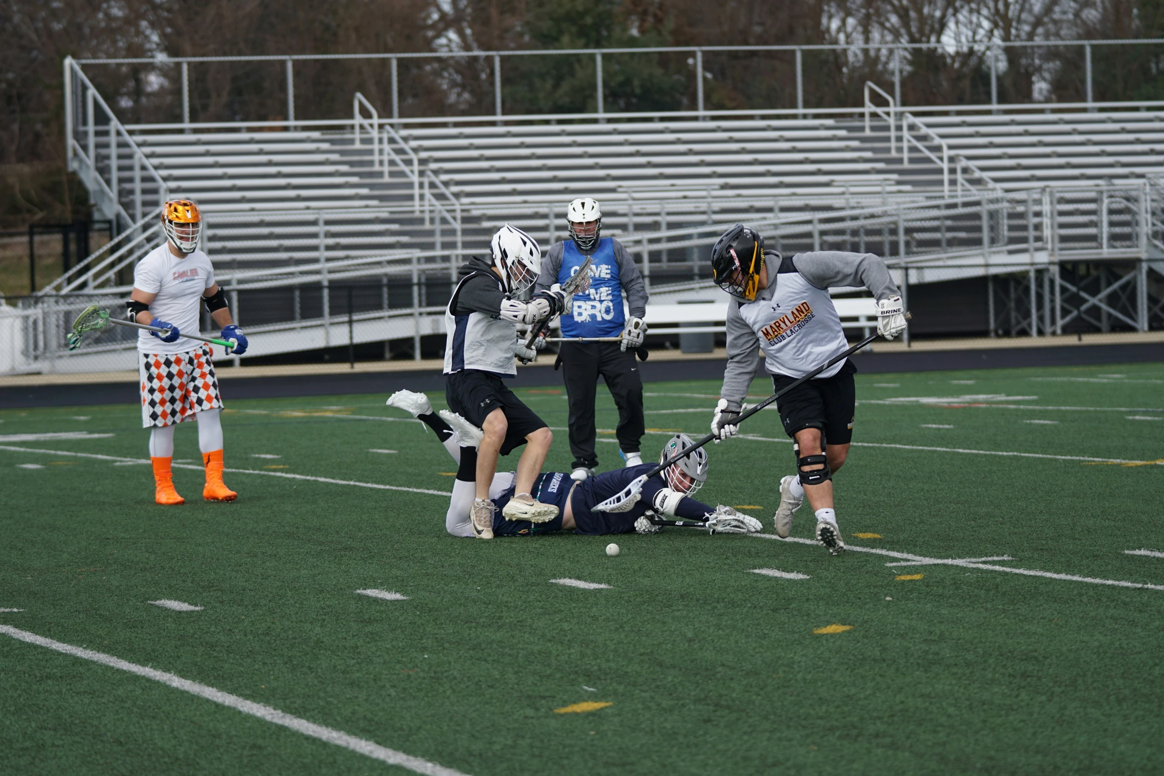 three young men on the field playing lacrosse