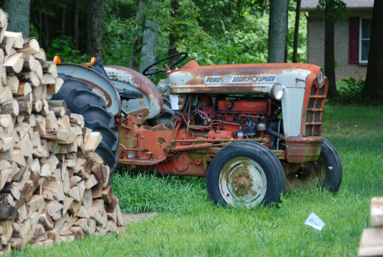 a large farmall tractor is sitting outside in the grass