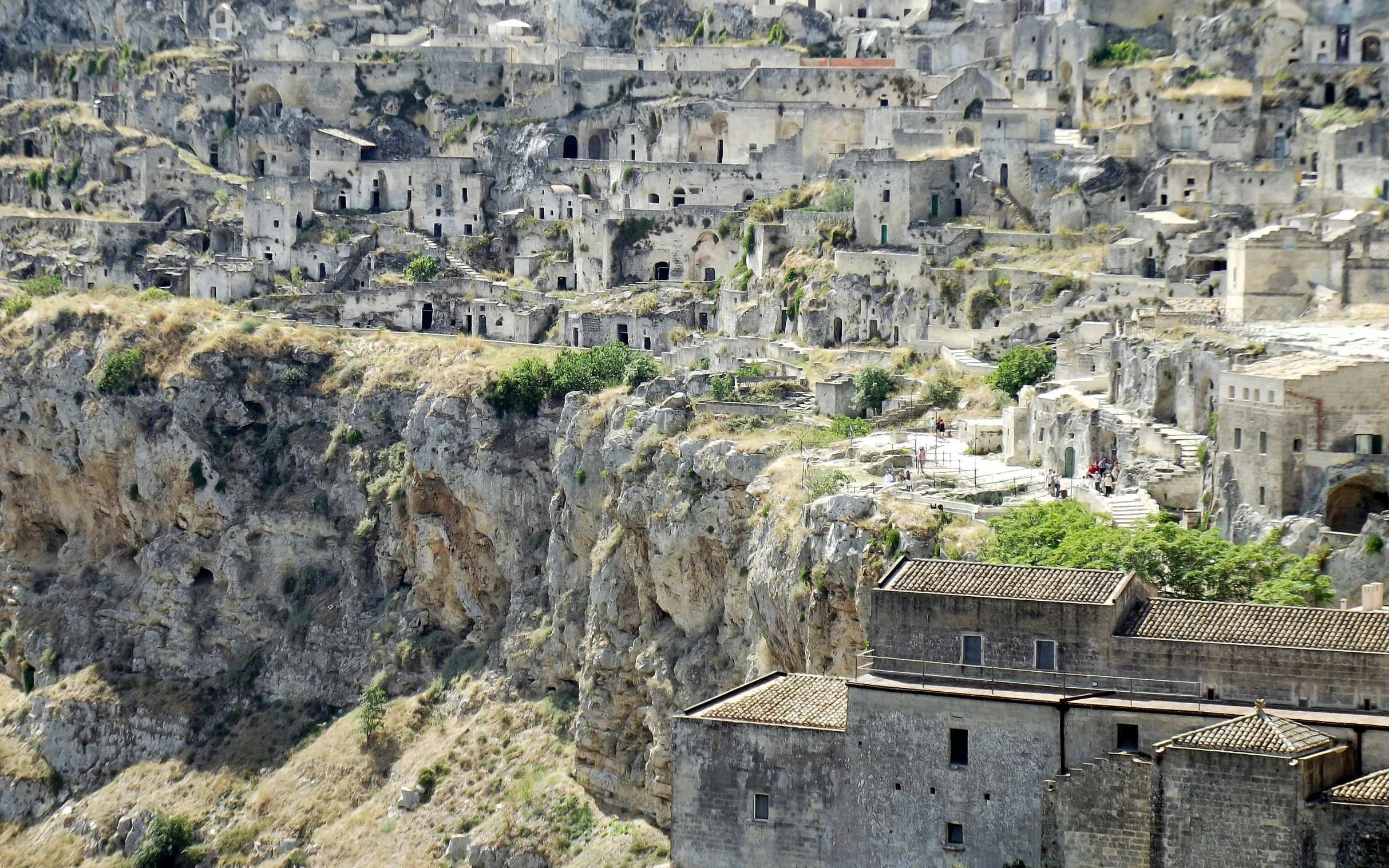 several old buildings on a mountain and trees