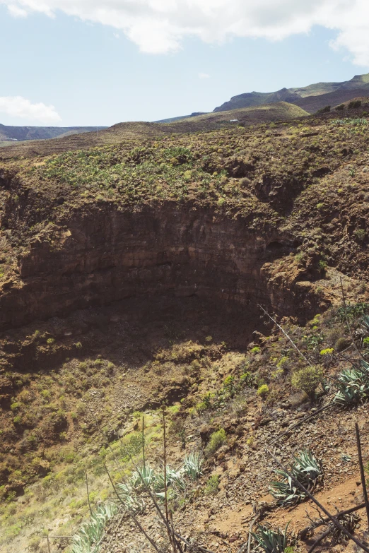 a mountain area with dirt and brush in the middle