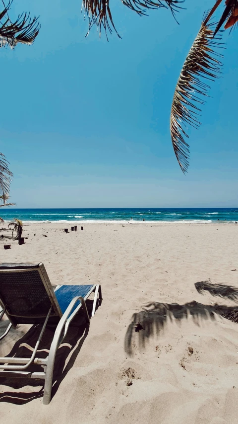 there are two chairs sitting on the sand