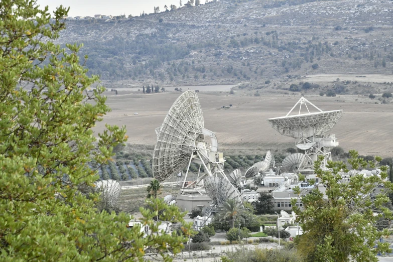 large antennae sitting above a city with some trees