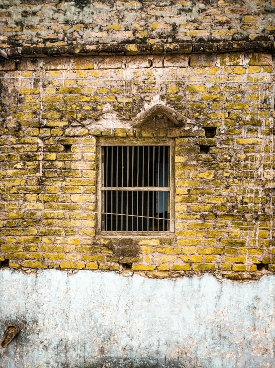 window with bars on an old stone wall
