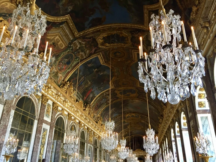 a room with lots of chandeliers and painted ceilings