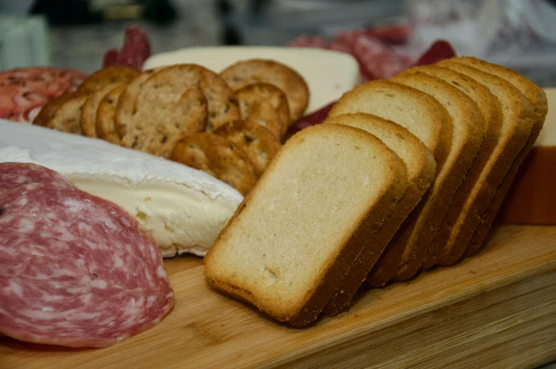 a tray holds some different types of meat and cheeses