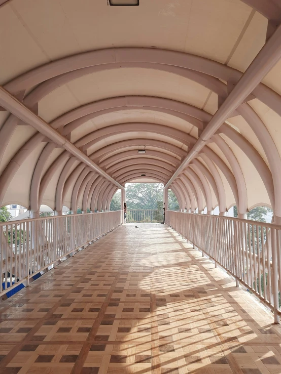 a walkway covered with wooden tiles leading to a balcony