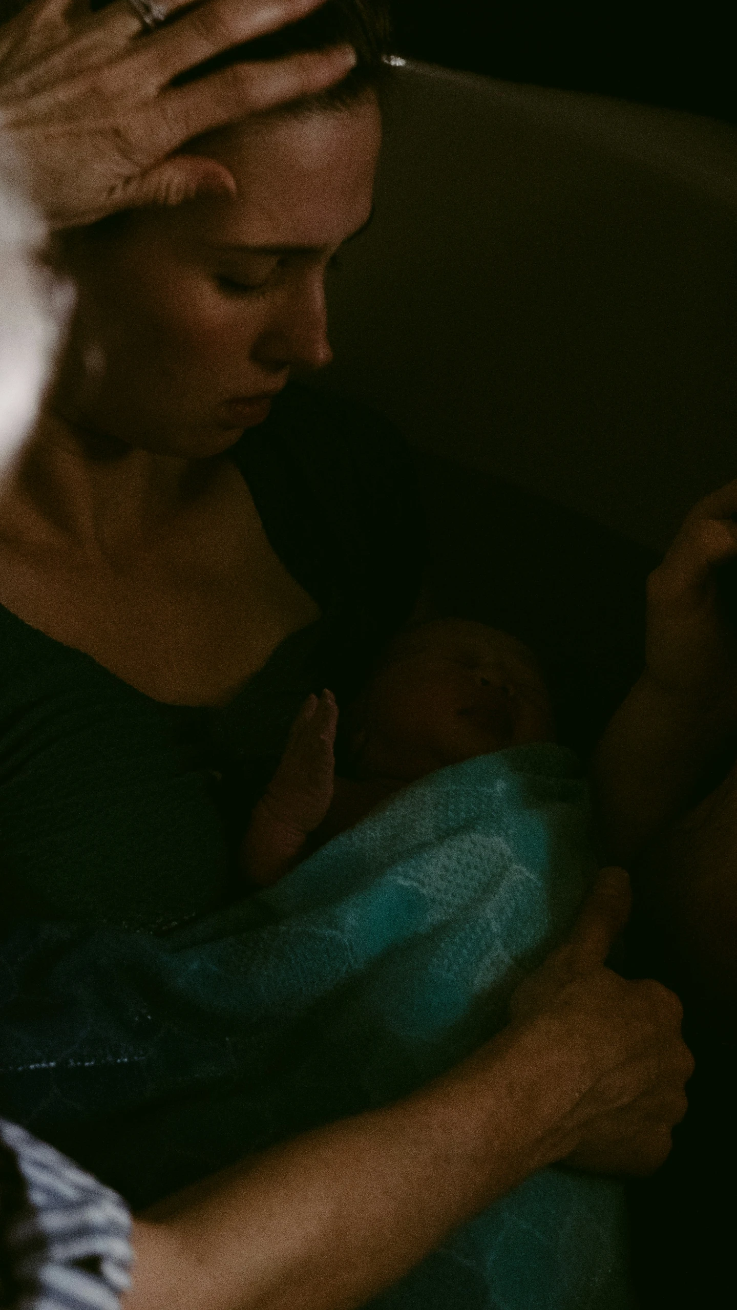 a woman in a dark po with her baby and the baby is holding a small cup