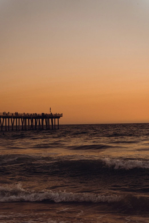 a pier is shown with waves in the foreground