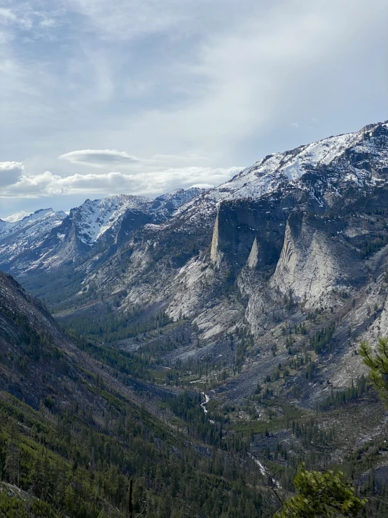 a rocky valley covered in snow with tall mountains on both sides