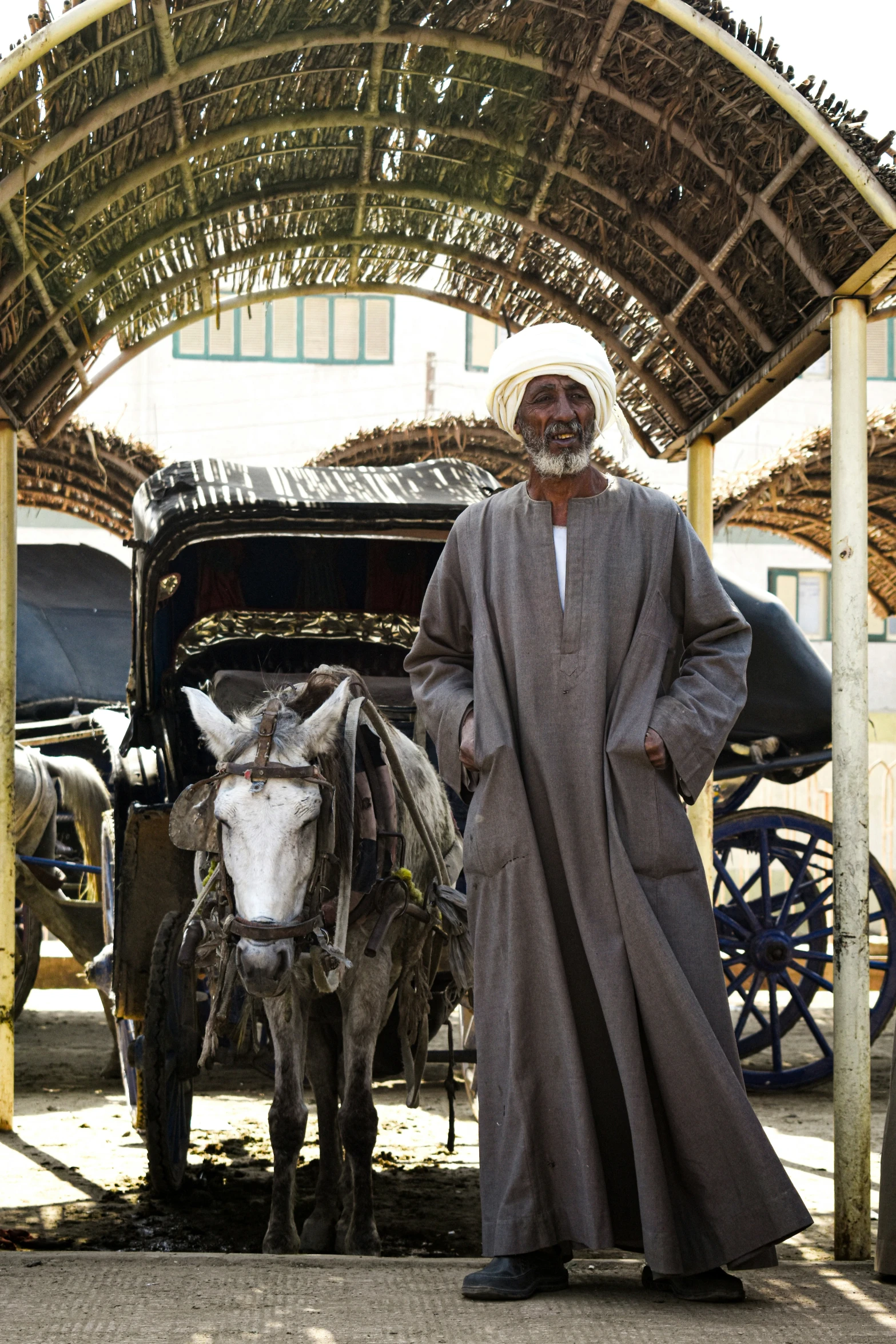 a man standing next to a donkey under a covered area