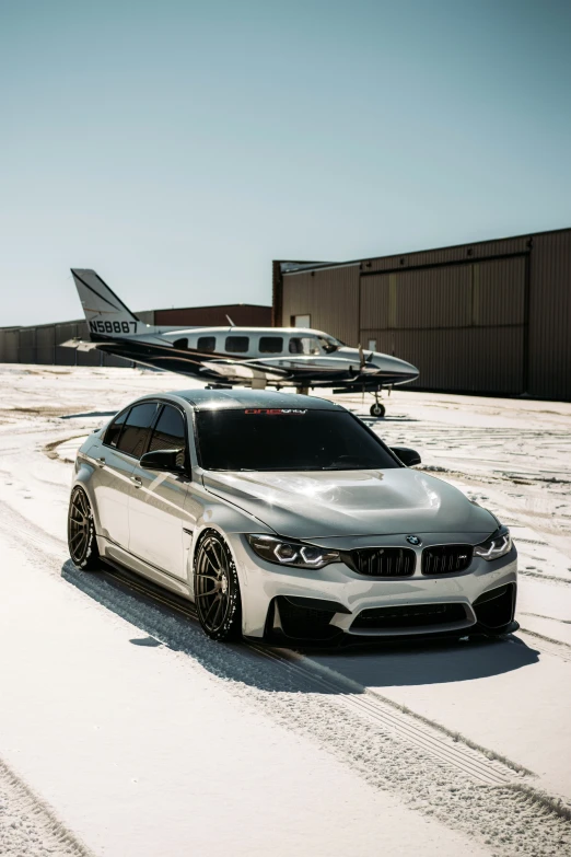 a car sitting on a snow covered runway next to a jet