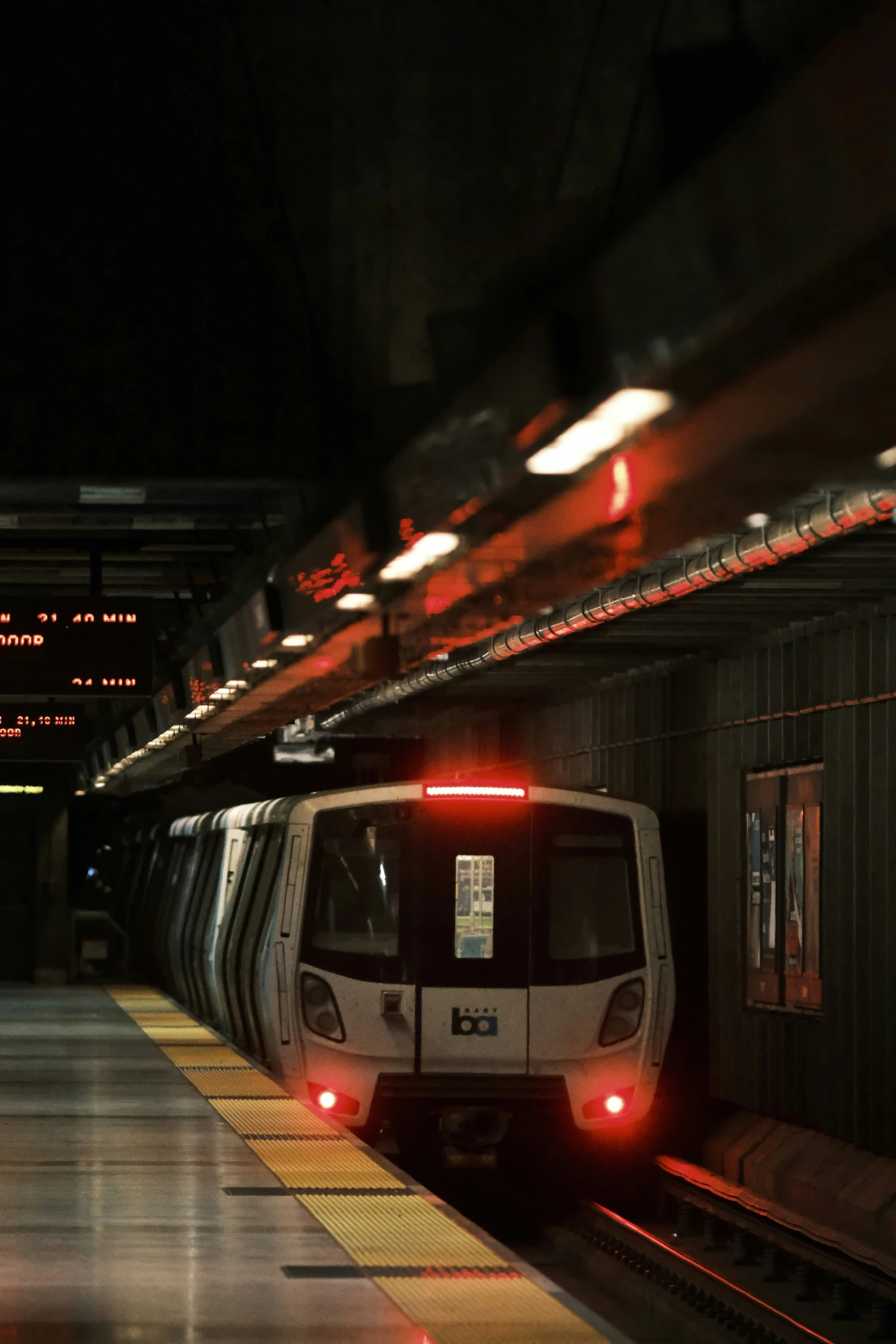 a train with its lights on is at the platform