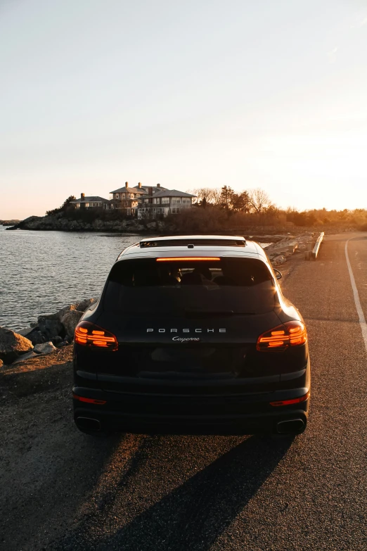 black car parked at the edge of a lake