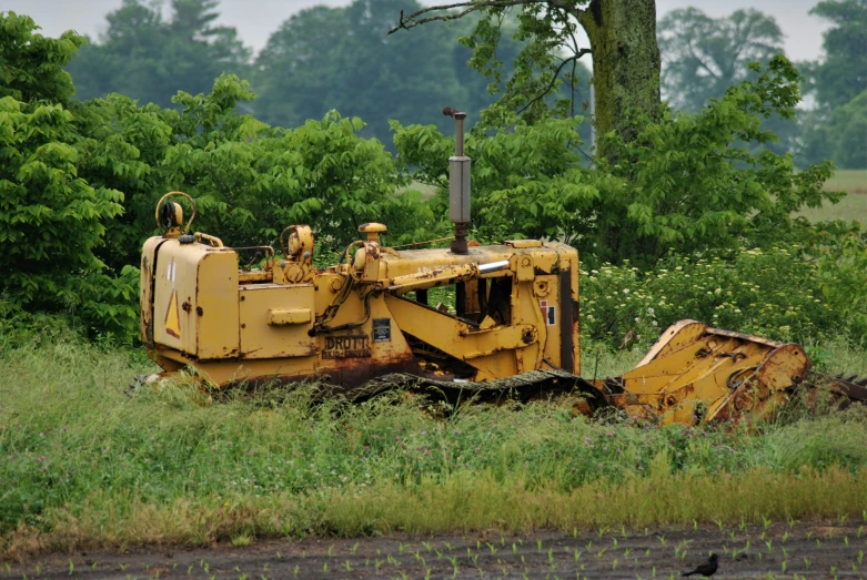 an old bulldozer is sitting in the grass