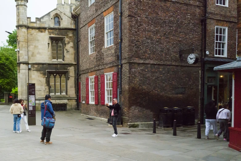 a group of people walking around outside a building