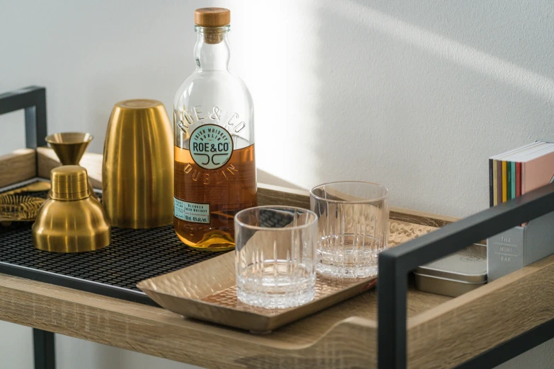glassware and a bottle of alcohol are on a tray