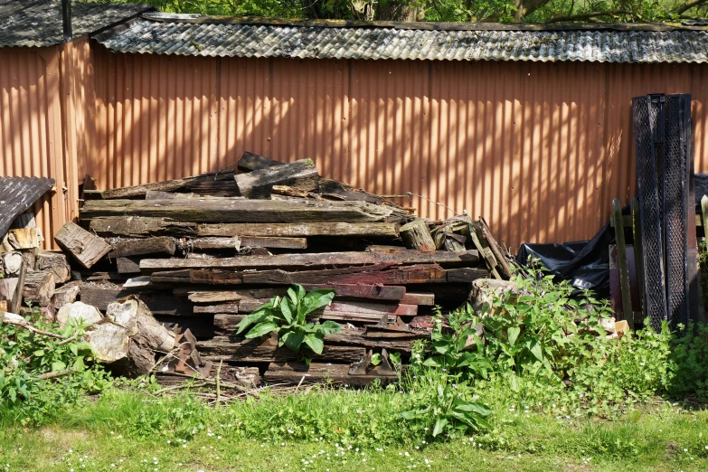 a pile of logs in front of a brown building