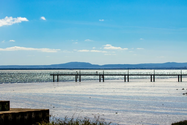 a pier extends into the ocean on a sunny day