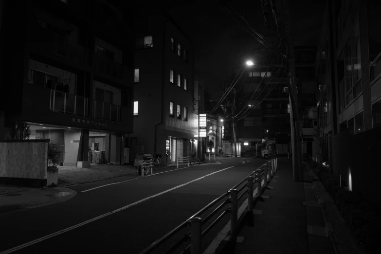 an empty city street with benches at night