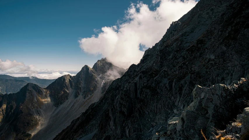 there are clouds coming down the mountain mountains