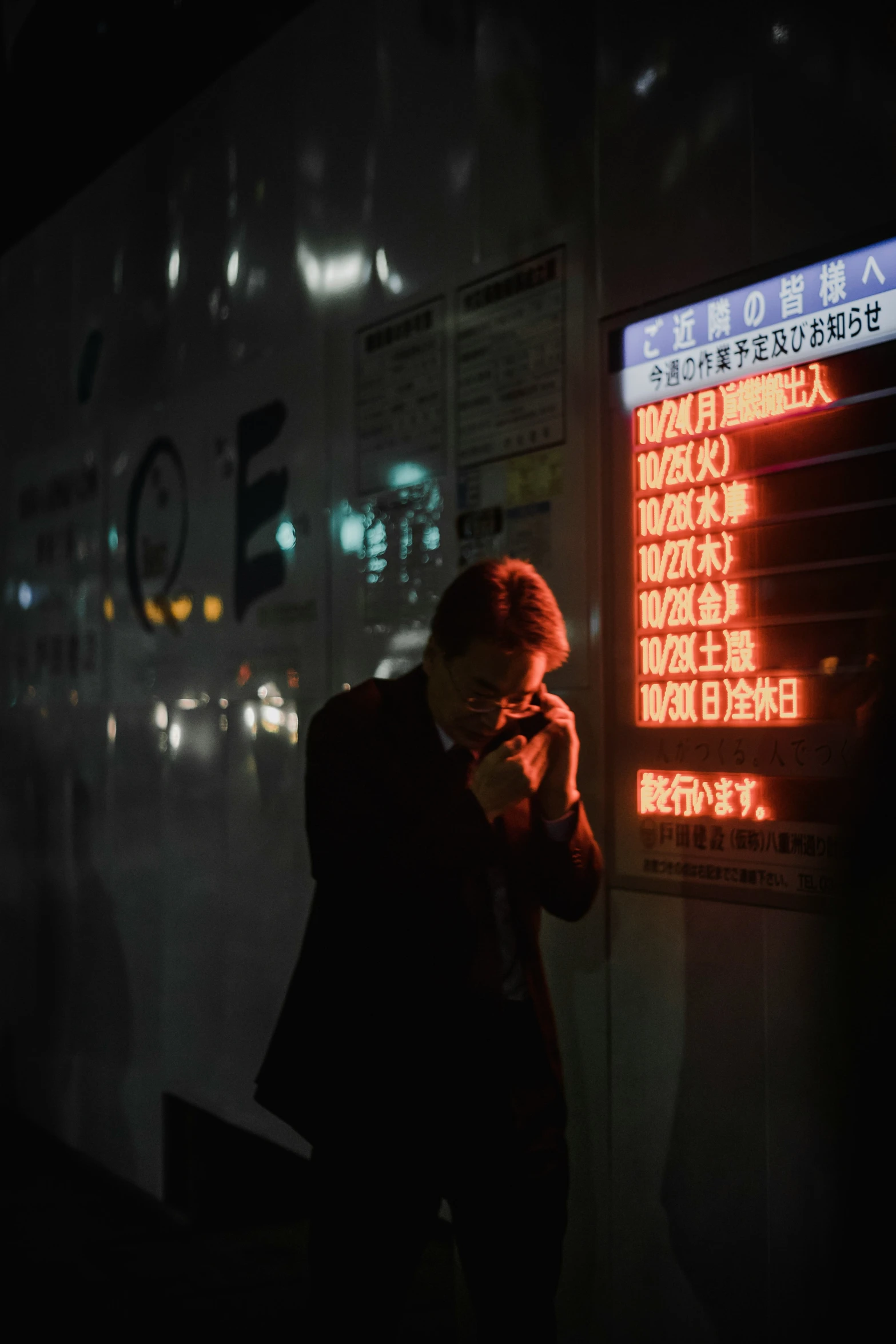 man on his phone in a dark corner