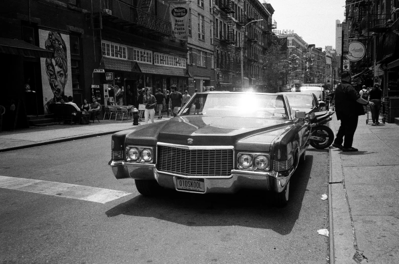 a black and white pograph of a car driving in the street