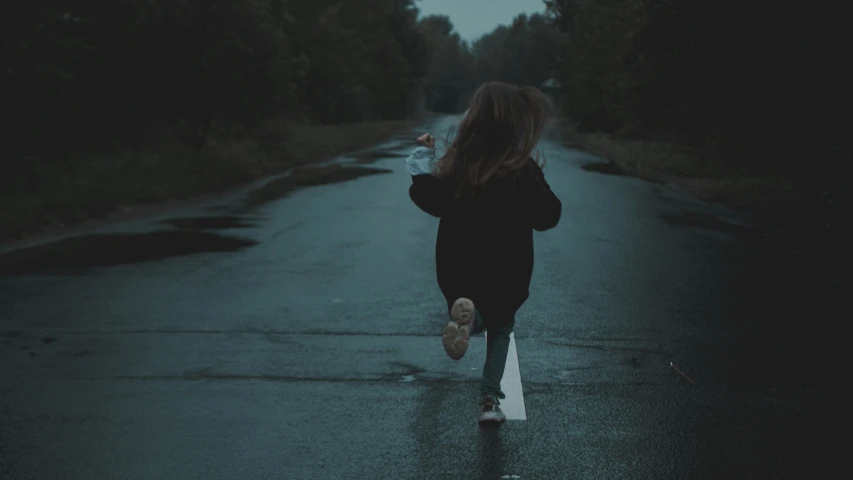 woman walking down the road on a wet, rainy night