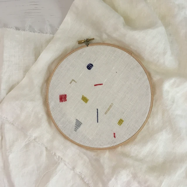 the embroidery pattern is on a sheet with a piece of fabric