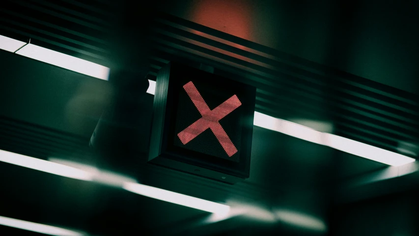 an illuminated railroad crossing sign on a train station