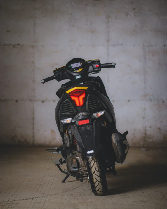 the motorcycle is parked against a wall in a parking garage