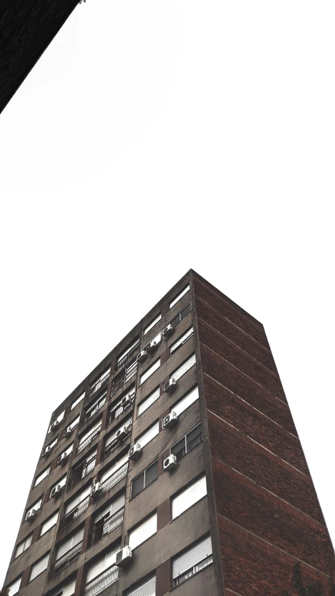 looking up at a high - rise building with windows