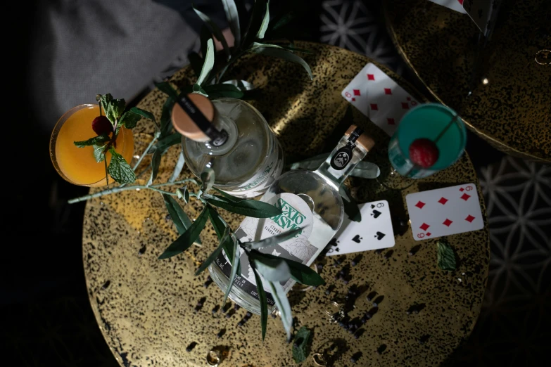 cards and wine sit on top of a golden table