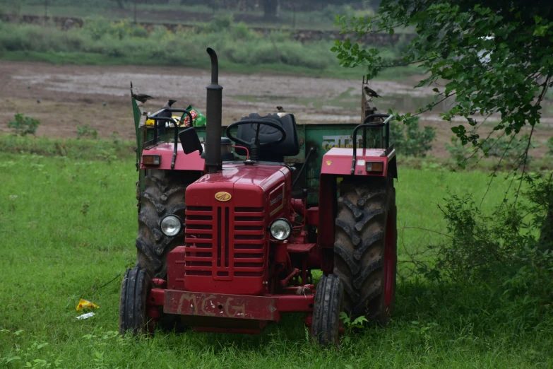 a large red tractor on a grassy field