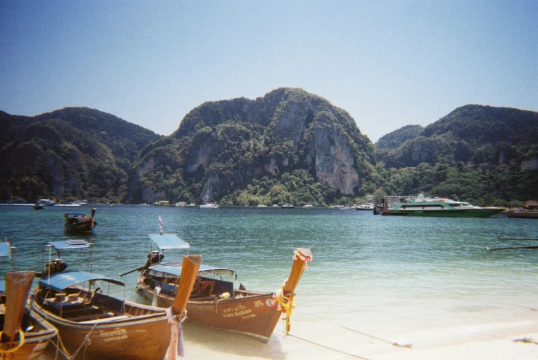 two boats on the beach in front of mountains