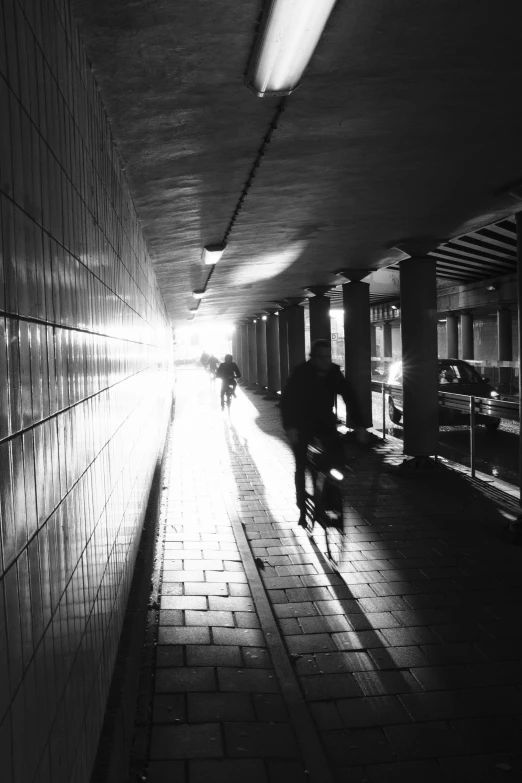 silhouettes of people riding bikes through a tunnel