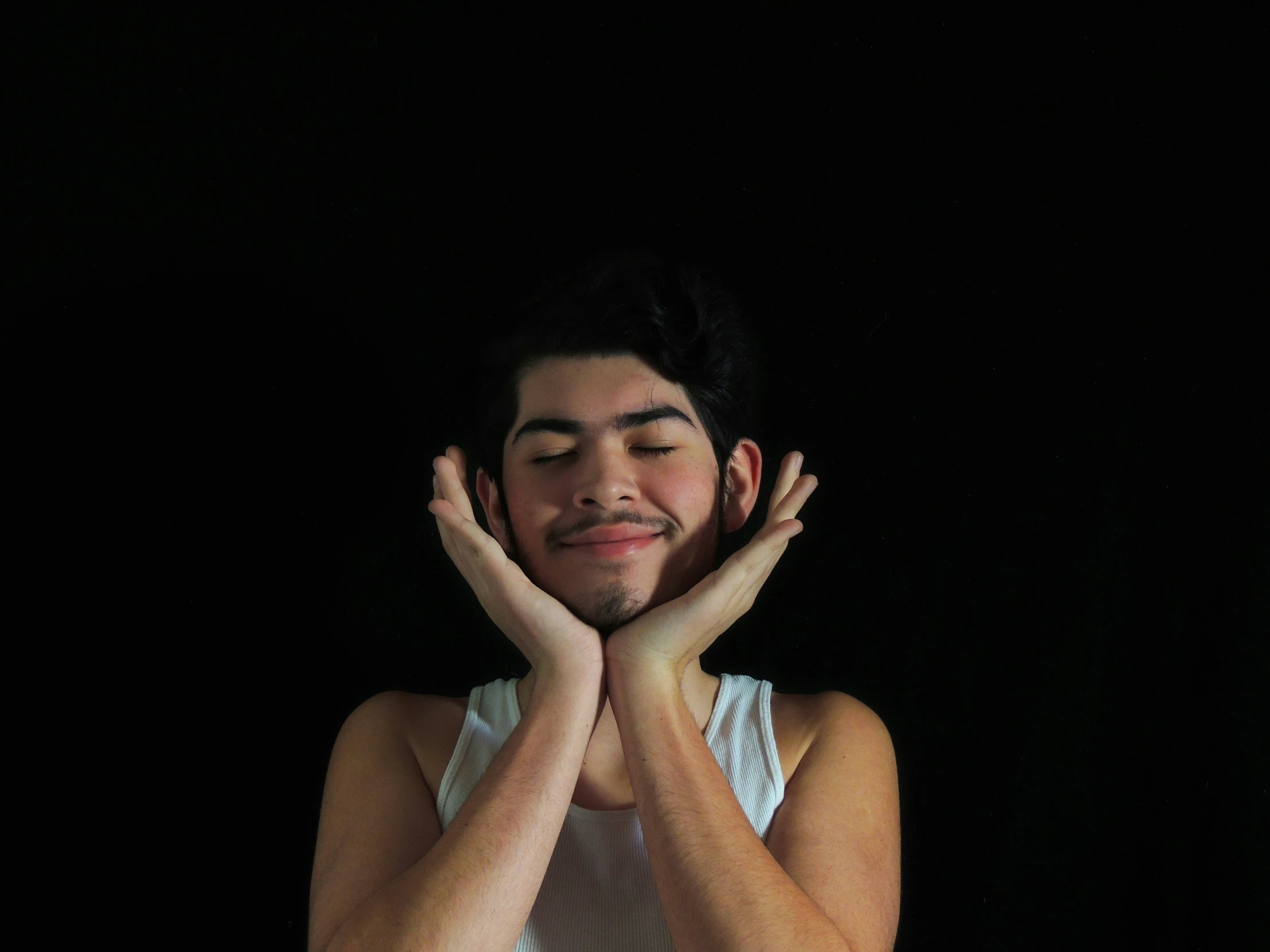 a man smiling with his hands behind his head