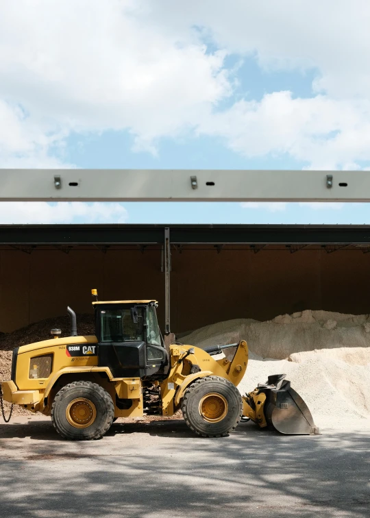 a loader is parked near a pile of dirt