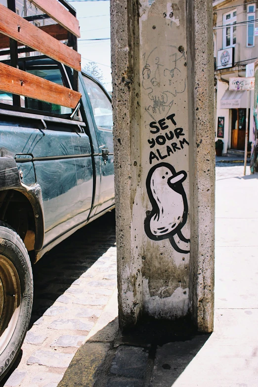 a street with graffiti on a wall next to a car