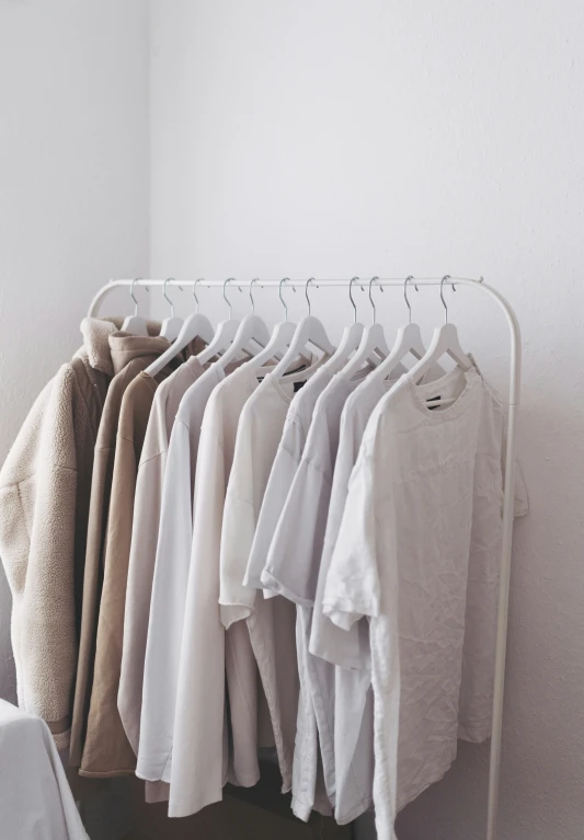 an ironing rack full of sweaters and t - shirts