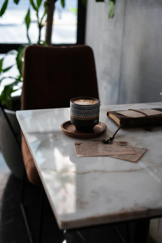 a coffee cup sitting on a marble table in an industrial - style restaurant