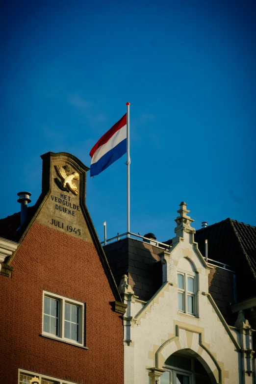 this flag on a building is flying above the entrance