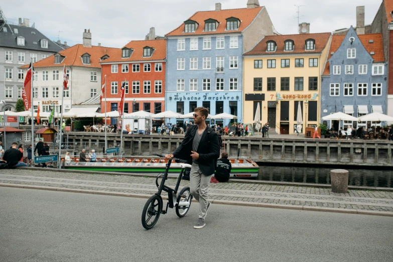 a man walking his bike down a street