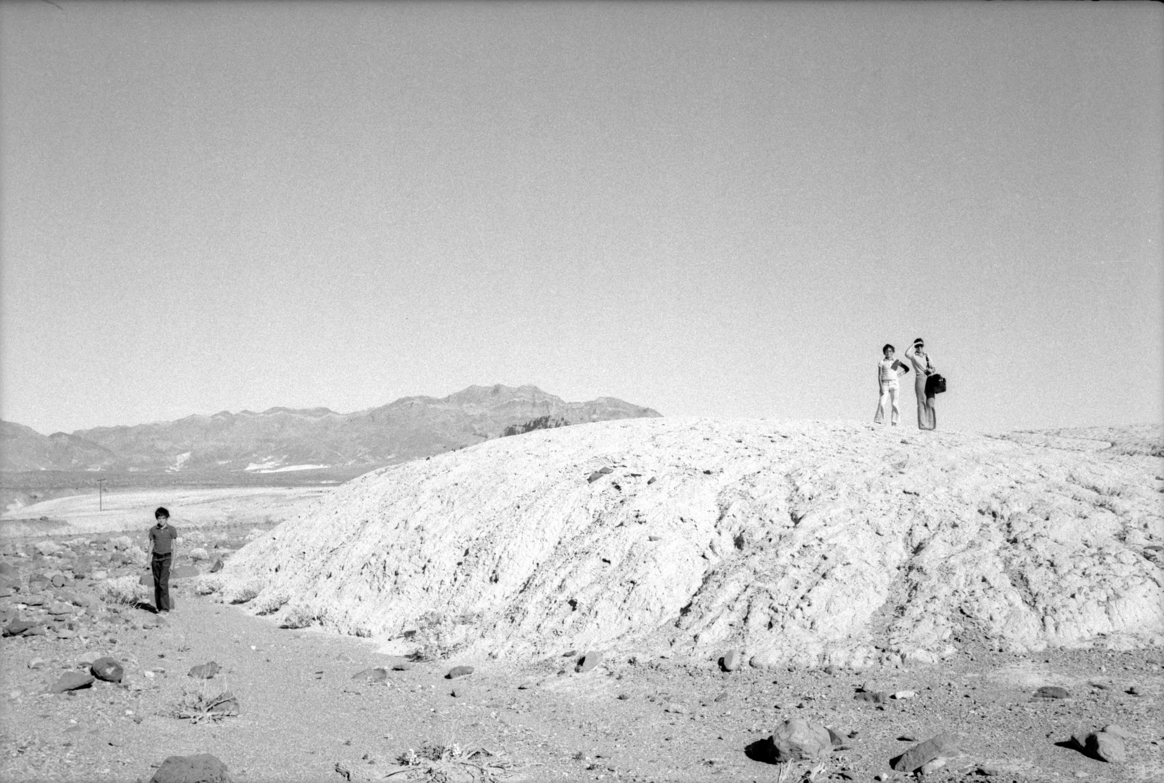 people standing on top of a mountain in the desert