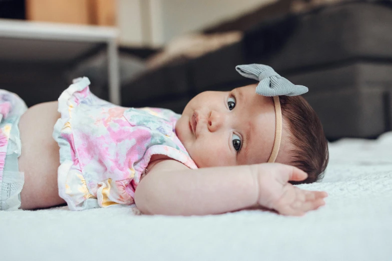 a close up of a baby laying on a bed