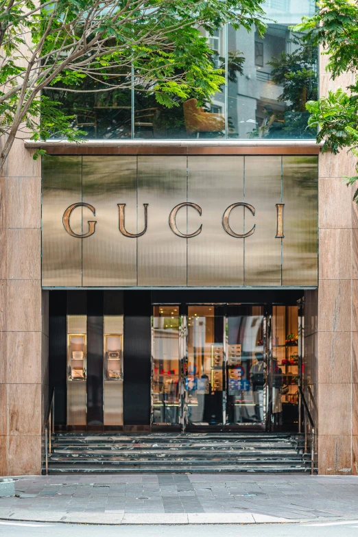 a man in black jacket and tie walking into the entrance to gucci
