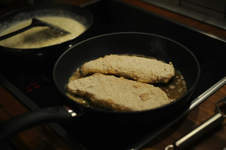 two pieces of bread frying in a set on a stove