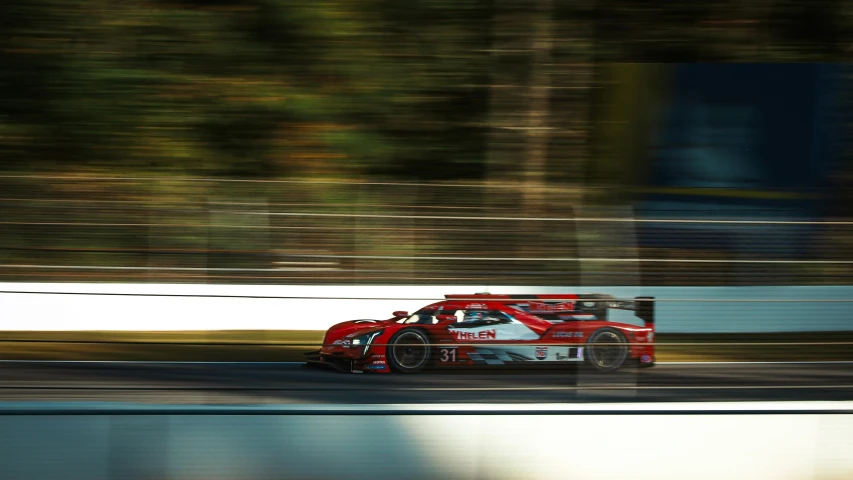 a red and white car driving on a track