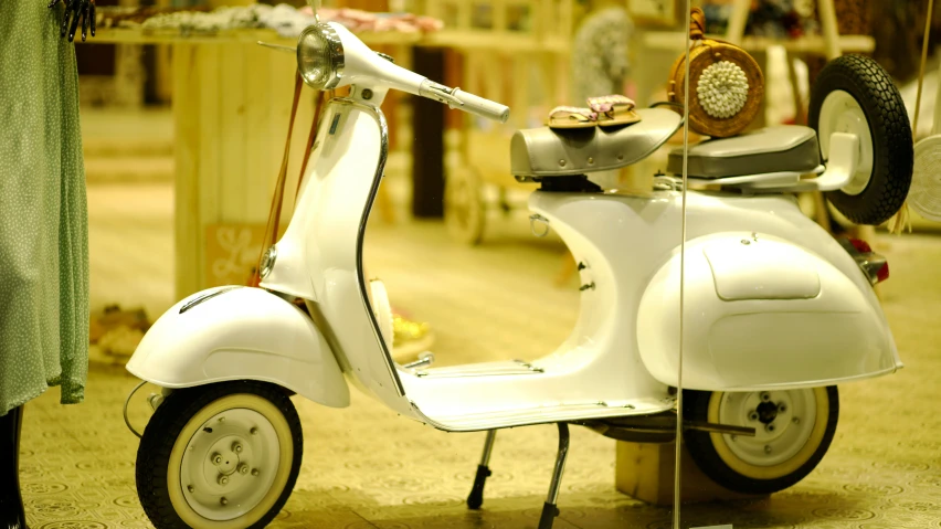 an old scooter with wheels parked next to some tables