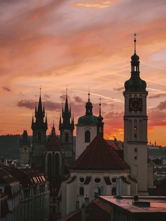 a clock tower rises above a city with tall buildings